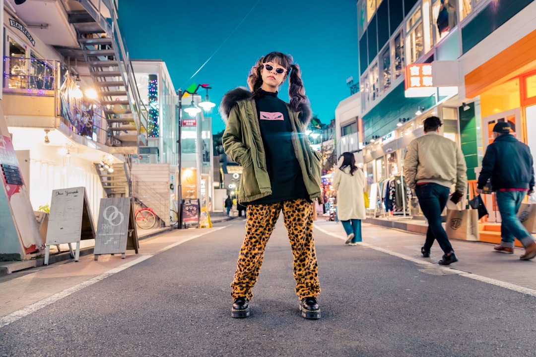woman in green jacket stands and pose on street y gfnfzr0hy